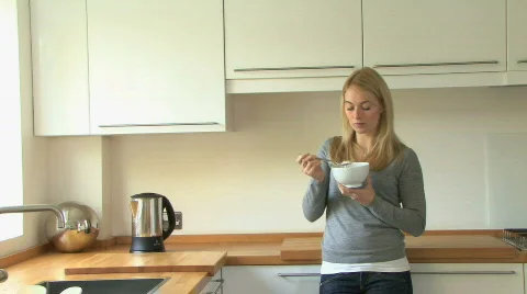 MS PAN OF A YOUNG WOMAN EATING A YOGHURT Stock Footage