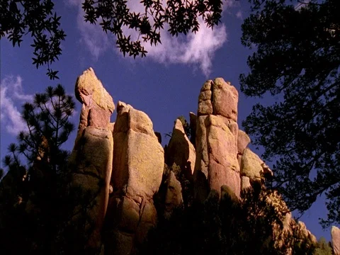 MS of rock formations, with moving white clouds in blue sky. Stock Footage 86751224
