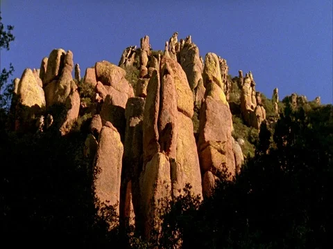 MS of rock formations, with moving white clouds in blue sky, zoom in to rocks Stock Footage 86751228