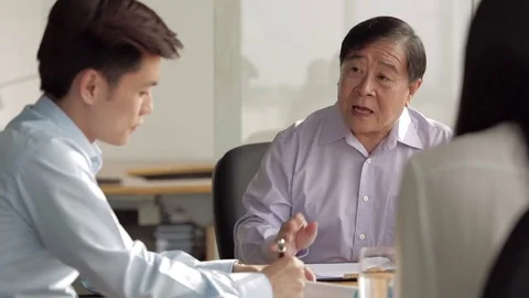 MS SELECTIVE FOCUS Senior businessman in discussion with two colleagues at Stock Footage 69939279