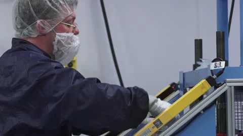 MS side angle of technician sitting at machine in cleanroom. Stock Footage 10895698