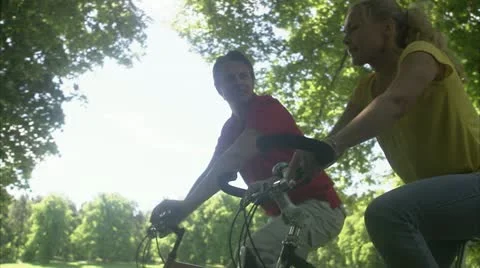 MS TS Two people riding bikes on treelined road Stock Footage 11341101