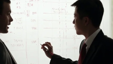 MS Two businessmen discussing and writing on white board / China Stock Footage 69936183
