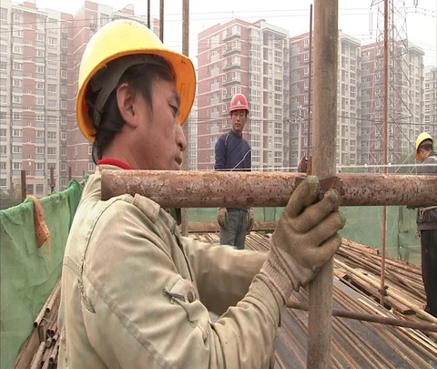 MS Worker in hard hat bolts scaffolding into place Stock Footage 86744323