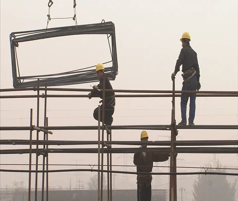 MS workers atop scaffolding as crane lowers metal frames Stock Footage 86744348