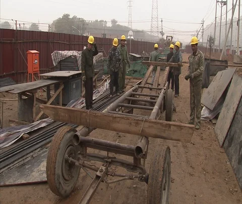 MS workers in hard hats begin loading cart with iron bars Video stock 86744263