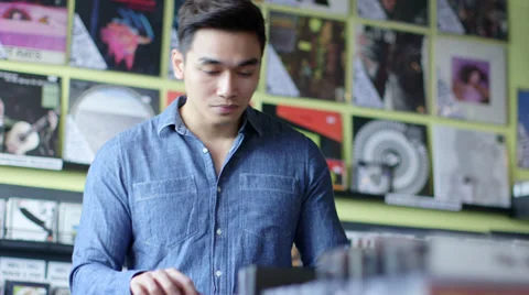MS A Young Man Browses through a rack of vintage records Stock Footage 38128376