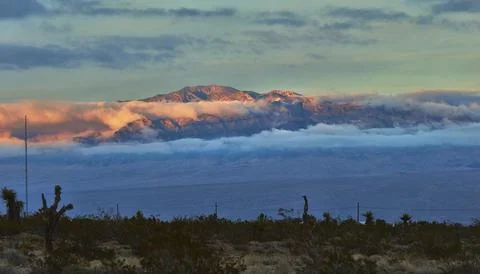 Mt Charleston Desert Panorama with Dramatic Cloud Layer and Sunlit Peaks 写真素材