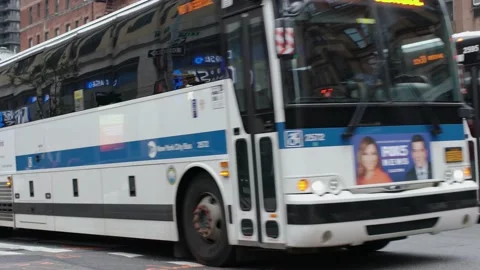 MTA Bus crossing Intersection followed by traffic in NYC Stock Footage 147968402