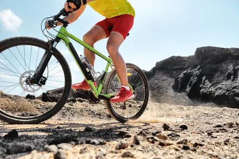 MTB mountain biking athlete man riding bike fast in trail dust. Closeup of legs Stock Photos