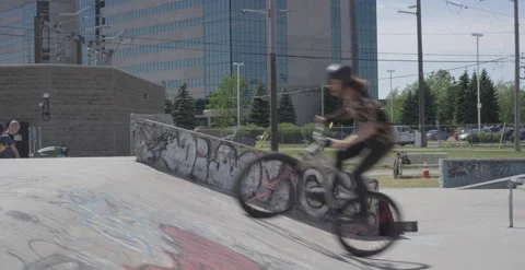 MTB rider does a footjam tailwhip on a skatepark ramp Stock Footage 157168429