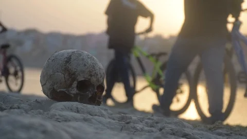 MTB riders passing by a real human skull in varanasi, India Stock Footage 114211569