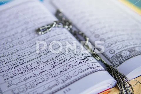 Muar, Malaysia - March 12, 2019 - Close up view of an open Quran and Muslim p Stock Photos