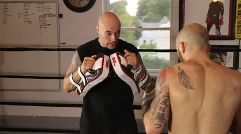 Muay Thai fighter practice his techniques while coach holds the pads Stock Footage 22085086