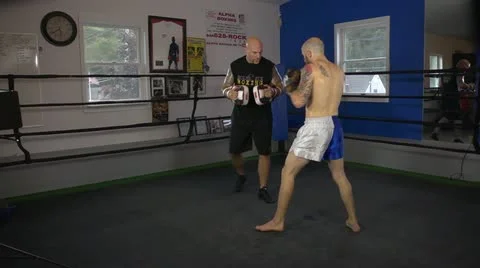 Muay Thai fighter practice his techniques with a coach in a ring Stock Footage 22085183