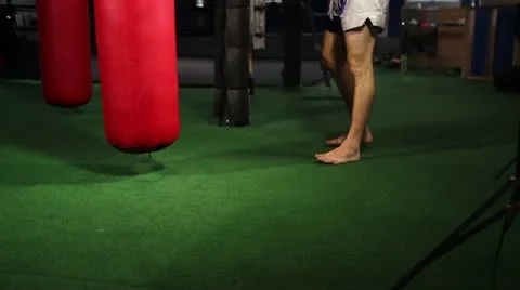Muay Thai fighter practices knee strikes on heavy bag Stock Footage 22078823