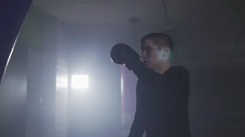 Muay thai fighter training with punching bag. Kickboxer punching in slow motion Video stock 109791445