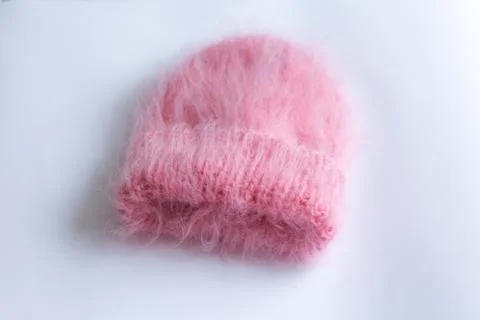 Much fluffy and warm hat pink knitted by hand on a white background Stock Photos