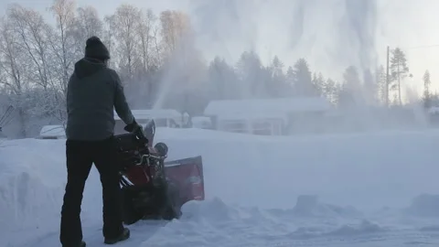 Much snow blowing from snow blowing machine, rear view video on man working.. Stock Footage 264773546