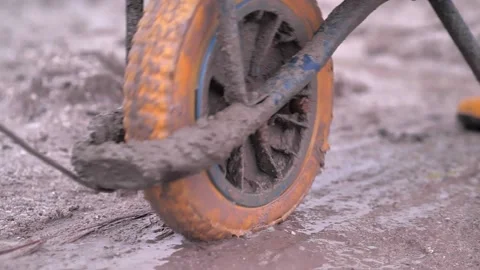 Mud boots pulling a wheelbarrow on a construction site Video stock 158740640
