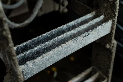 Mud-covered metal steps of construction equipment showing rugged texture Stock Photos