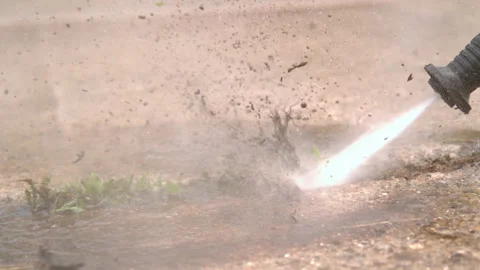 Mud exploding out of concrete cracks from pressure washer slow motion 4k Stock Footage 130689824