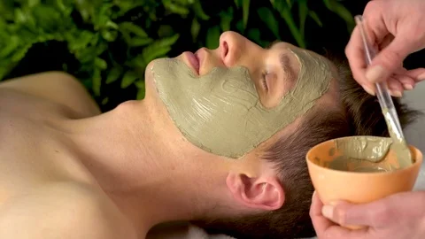 Mud facial mask of man in spa salon. Face massage . Stock Footage 82138984