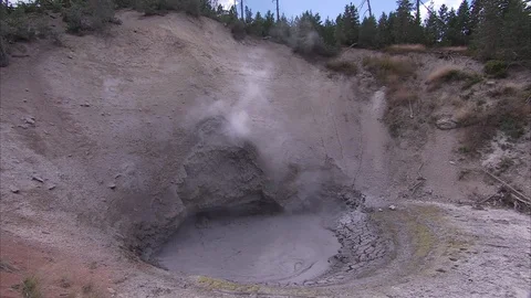 Mud pit in Yellowstone connected to hot spring, with bubbling water and steam. Stock Footage 86755733