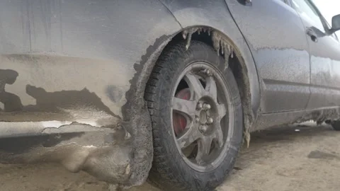 Mud-splattered car struggles through icy winter conditions Stock Footage 334164552