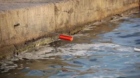 Mud on the surface of the sea washed up by waves to a concrete pier. Stock Footage 165201569