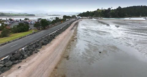 Muddy beach and tidal flats beside a coastal road. Sandspit, Warkworth, NZ Stock Footage 311287207