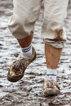 Muddy boots step through wet, thick mud Stock Photos