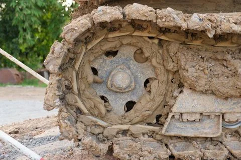 Muddy crawler track wheel construction machinery covered in thick clay outdoo Stock Photos