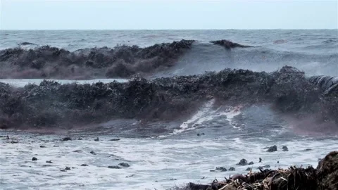 Muddy ocean waves crash onto rocks Stock Footage 251848503
