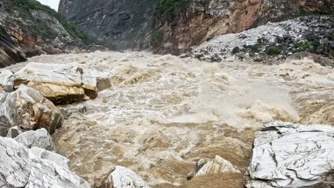 Muddy Rapids Churn Past Marble Boulders, Tiger Leaping Gorge, Yunnan Stock Footage 341346567