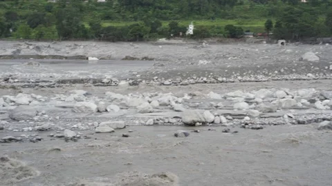Muddy river rapids surging around rocky gravel islands after flash flood Vidéo 345606361