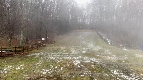 Muddy, Snow-Covered Hillside During Misty Winter Rainstorm Stock Footage 85282652