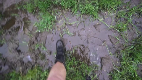 Muddy walk with a view looking down at black hiking boots Vidéo 135058280