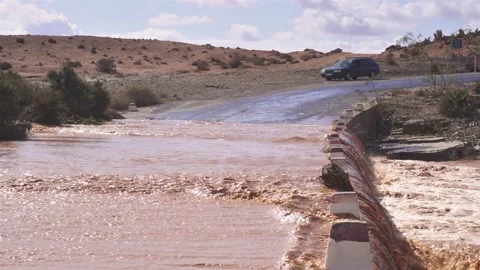 Muddy water of Flooded river flows over bridge in Africa country road after rain Stock Footage 235918083