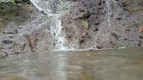 Muddy Waterfall and Rocky Cliff in Natural Outdoor Setting Stock Footage 329782284