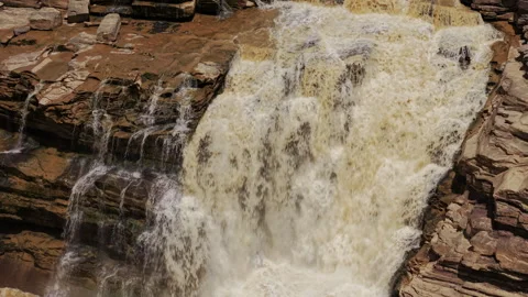 Muddy Waterfall Cascading Over Rocky Cliffs Pull Back Shot Stockbeeldmateriaal 342046016