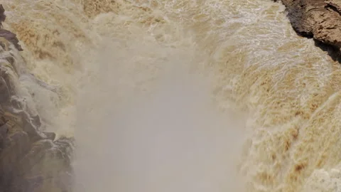 Muddy waterfall mist chaotic power forward descend fluid dynamics Stock Footage 342049859