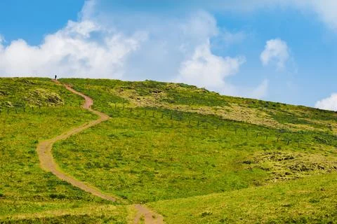 Muddy winding pathway passing through beautiful grass rolling hills of Chik.. 写真素材