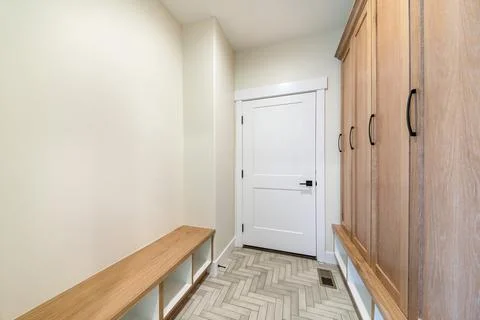 Mudroom interior with herringbone tile pattern flooring and wooden cabinet Stock Photos