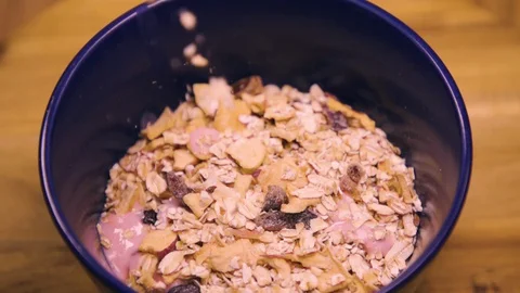 Muesli, cereal, corn flakes falling in a bowl  Stock Footage 128552237