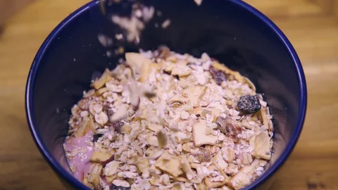 Muesli, cereal, corn flakes falling in a bowl  Stock Footage 128552470