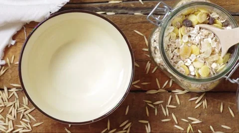 Muesli with oat flakes, corn and fruit in a bowl poured yogurt Stock Footage 51534192