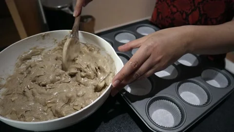 Muffin mixture being separated in to cases in Leeds, UK Stock Footage 130326626
