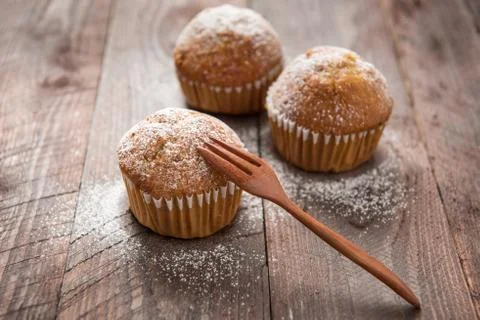 Muffins and fork on a wooden table. Stock Photos