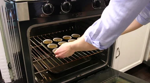 Muffins being placed into oven Stock Footage 61404190